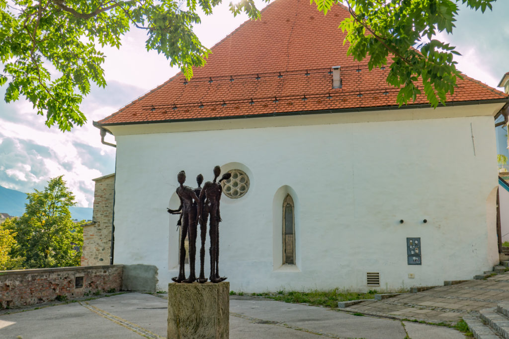 Widok na plac z rzeźbą i budynek Synagogi