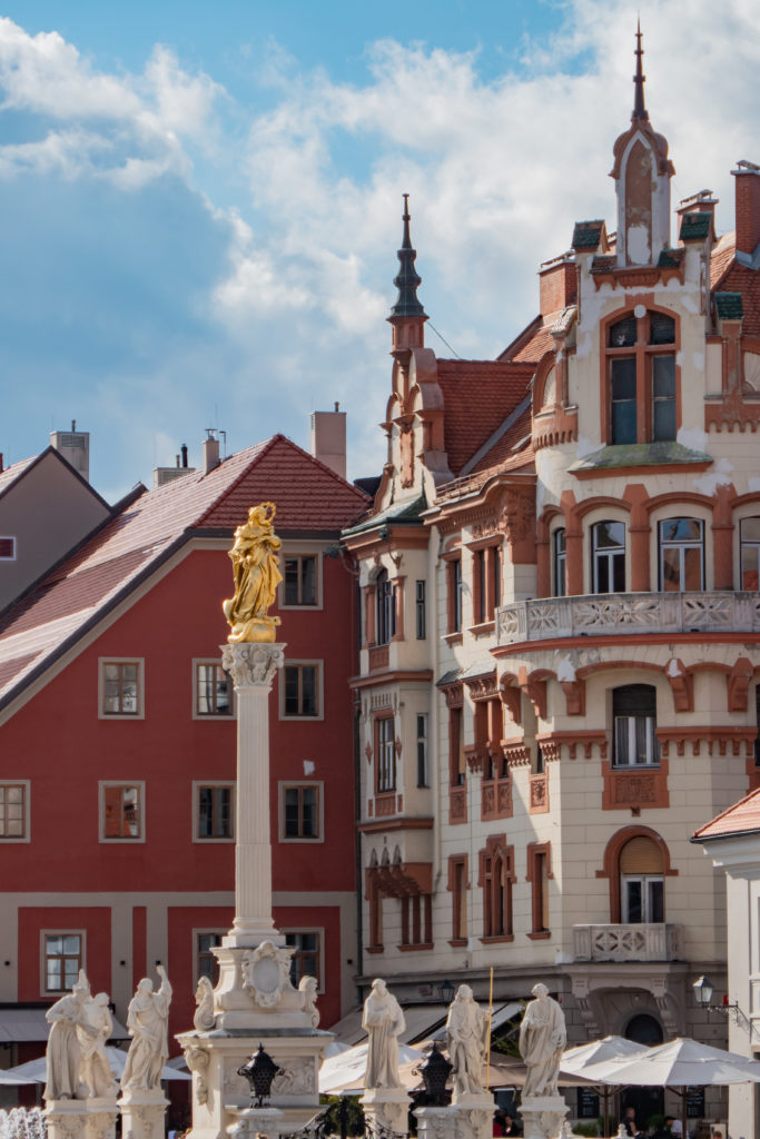 Widok na figurę na kolumnie oraz kamienicę w tle