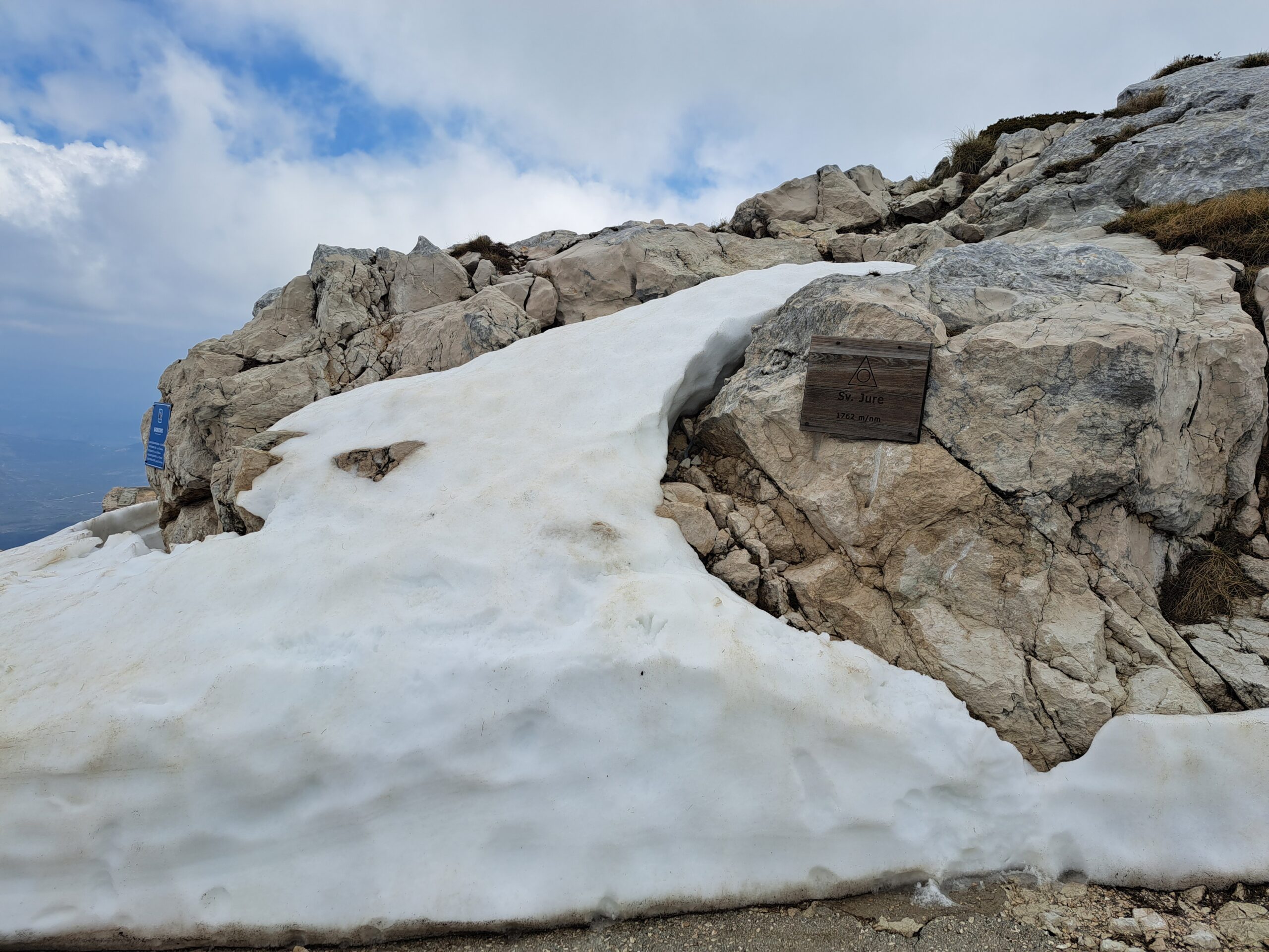 Tabliczka z napisem Sv. Jure 1762 m.n.p.m na szczycie góry przymocowana do skały