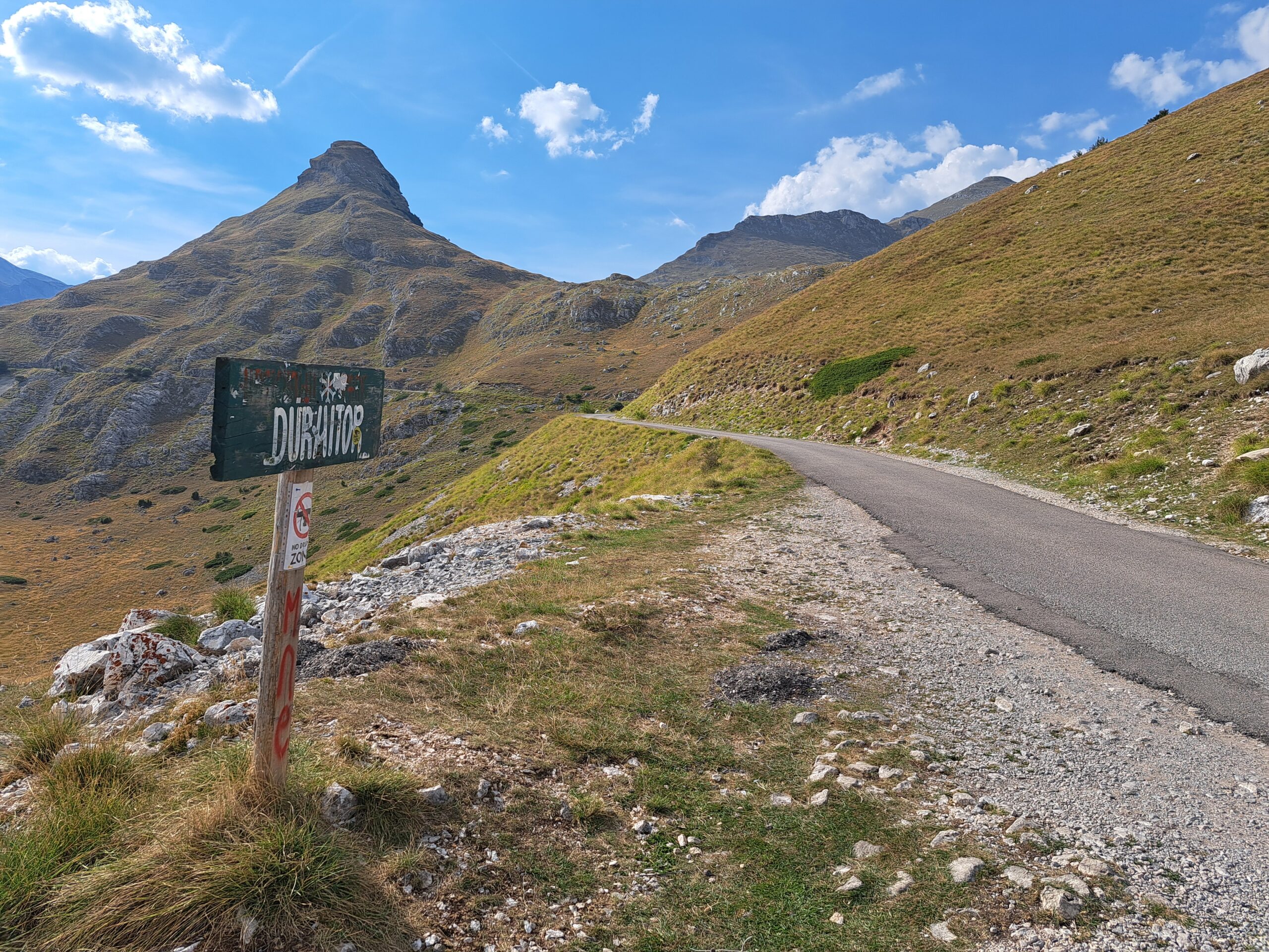 Zielona, drewniana tabliczka z napisem "Durmitor", w tle góry